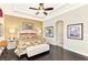Bright main bedroom features tray ceiling, ceiling fan, large window, and hardwood floors at 23494 Copperleaf Dr, Venice, FL 34293