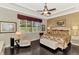 Bright main bedroom features tray ceiling, ceiling fan, large window, and hardwood floors at 23494 Copperleaf Dr, Venice, FL 34293