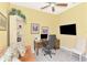 Bright office area with yellow walls, tiled floors, comfortable sofa, and a well-equipped desk space at 23494 Copperleaf Dr, Venice, FL 34293