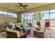 Spacious screened-in patio featuring an outdoor kitchen, comfortable seating, and a serene lake view at 23494 Copperleaf Dr, Venice, FL 34293