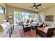 Inviting screened patio with outdoor kitchen, comfortable seating, ceiling fan, and a tranquil lake view at 23494 Copperleaf Dr, Venice, FL 34293
