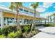 Patio seating with tables and palms outside a bright yellow restaurant, overlooking the water at 23494 Copperleaf Dr, Venice, FL 34293