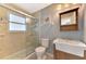 Bathroom featuring glass-enclosed tiled shower, vanity sink, and window for natural light at 23516 Peachland Blvd, Port Charlotte, FL 33954