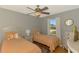 Cozy bedroom with twin beds, ceiling fan, window providing natural light, and neutral paint scheme at 23516 Peachland Blvd, Port Charlotte, FL 33954