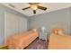 Comfortable bedroom with twin beds, neutral walls, a ceiling fan, and stylish furnishings at 23516 Peachland Blvd, Port Charlotte, FL 33954