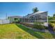 Home exterior with a screened lanai and well-kept lawn, providing a perfect outdoor space at 23516 Peachland Blvd, Port Charlotte, FL 33954