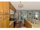 Well-lit kitchen featuring wood cabinets, stainless steel appliances, and granite countertops with pool views at 23516 Peachland Blvd, Port Charlotte, FL 33954