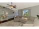 Spacious living room featuring neutral colors, hardwood flooring, and a large comfortable couch bathed in natural light at 23516 Peachland Blvd, Port Charlotte, FL 33954