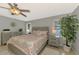 Comfortable main bedroom with neutral paint, ceiling fan, tile floors, and large windows at 23516 Peachland Blvd, Port Charlotte, FL 33954
