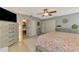 Main bedroom featuring tile flooring, neutral paint, ceiling fan, ensuite bathroom, and large closet space at 23516 Peachland Blvd, Port Charlotte, FL 33954