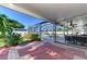 Screened patio with brick flooring and a view of the sparkling pool and well-manicured backyard at 23516 Peachland Blvd, Port Charlotte, FL 33954