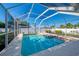 Sparkling pool features screened-in enclosure, clear blue water, and a spacious concrete deck for lounging at 23516 Peachland Blvd, Port Charlotte, FL 33954
