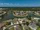 A picturesque aerial view of a lakeside home with lush landscaping, offering serene views in a beautiful community at 24477 Lakeside Mnr, Punta Gorda, FL 33980