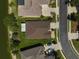 Bird's eye view of a home showing the roof, driveway, landscaping, and nearby lake at 24477 Lakeside Mnr, Punta Gorda, FL 33980