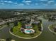 An elevated perspective of a resort-style community pool area with lush landscaping and serene lakeside views at 24477 Lakeside Mnr, Punta Gorda, FL 33980