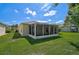 Exterior view of the back of the property and enclosed lanai with lush green lawn at 24477 Lakeside Mnr, Punta Gorda, FL 33980