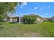Exterior view of the back of the property and enclosed lanai overlooking the lush green lawn at 24477 Lakeside Mnr, Punta Gorda, FL 33980