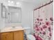 A bright bathroom with a vanity, toilet, and a shower with a decorative curtain at 24477 Lakeside Mnr, Punta Gorda, FL 33980