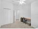 Bright bedroom featuring carpeted floors, a ceiling fan and light, and a built-in desk with a chair at 24477 Lakeside Mnr, Punta Gorda, FL 33980