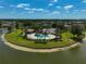 Aerial view of a resort-style community pool with ample seating, palm trees, and lake views at 24477 Lakeside Mnr, Punta Gorda, FL 33980
