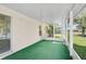Enclosed lanai with green carpet flooring, natural light, and screened windows overlooking the backyard at 24477 Lakeside Mnr, Punta Gorda, FL 33980