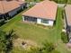 Aerial view of the backyard featuring a screened lanai and well manicured lawn at 264 Caserta Ct, Nokomis, FL 34275