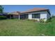 Lush backyard with green lawn and the exterior elevation of the home featuring a screened-in patio at 264 Caserta Ct, Nokomis, FL 34275