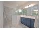 Beautiful bathroom with walk-in shower, blue vanity, and a large mirror at 264 Caserta Ct, Nokomis, FL 34275