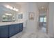Bathroom with blue vanity, large mirror, and a glimpse into the bedroom at 264 Caserta Ct, Nokomis, FL 34275