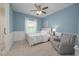 Charming bedroom with blue walls, white trim, a ceiling fan, and a comfortable armchair at 264 Caserta Ct, Nokomis, FL 34275