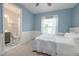 Comfortable bedroom with an attached bathroom, light blue walls, and neutral carpet at 264 Caserta Ct, Nokomis, FL 34275