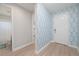 Hallway with patterned wallpaper, leading to a bathroom, bedroom, and the front door at 264 Caserta Ct, Nokomis, FL 34275