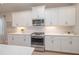 Well-appointed kitchen features stainless steel appliances, white cabinetry, and subway tile backsplash at 264 Caserta Ct, Nokomis, FL 34275