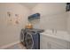 Laundry room with modern washer and dryer, utility sink, and ample storage space at 264 Caserta Ct, Nokomis, FL 34275