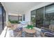 Cozy screened patio with wicker furniture and blue cushions, perfect for outdoor relaxation at 264 Caserta Ct, Nokomis, FL 34275