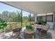 Inviting screened in patio with wicker furniture and a view of the lush backyard at 264 Caserta Ct, Nokomis, FL 34275