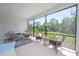 Inviting screened-in patio featuring comfortable wicker seating and scenic backyard views at 264 Caserta Ct, Nokomis, FL 34275