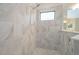 Spacious walk-in shower featuring tile walls, a showerhead, and a window for natural light at 264 Caserta Ct, Nokomis, FL 34275