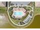 Aerial view of community pool and amenity center, landscaped grounds, parking, tiki huts, and bocce ball at 268 Ibiza Loop, Venice, FL 34292