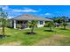 Beautifully landscaped backyard featuring lush green grass, young palm trees, and a screened-in patio perfect for outdoor living at 268 Ibiza Loop, Venice, FL 34292