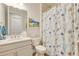Bathroom featuring a white vanity, decorative shower curtain, and beach-themed art at 268 Ibiza Loop, Venice, FL 34292