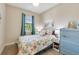 Cozy bedroom with a patterned quilt, blue accents, and ample natural light at 268 Ibiza Loop, Venice, FL 34292
