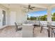 Covered patio with tile flooring, ceiling fan, comfortable seating, and a view of the surrounding landscape at 268 Ibiza Loop, Venice, FL 34292