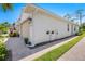 Angle view of stucco home with 2 car garage, brick paved driveway, and tasteful landscaping at 268 Ibiza Loop, Venice, FL 34292