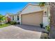 Attached two car garage with brick paver driveway and manicured landscaping at 268 Ibiza Loop, Venice, FL 34292