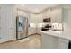 Modern kitchen with white cabinets, stainless steel appliances, and tile flooring at 268 Ibiza Loop, Venice, FL 34292