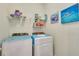 Efficient laundry room with modern washer and dryer units and organized shelving at 268 Ibiza Loop, Venice, FL 34292