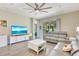 Bright living room featuring a gray leather sofa, white furniture, and tile flooring at 268 Ibiza Loop, Venice, FL 34292