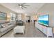 Open-concept living room with modern decor, gray tile floors, and a comfortable leather sofa at 268 Ibiza Loop, Venice, FL 34292