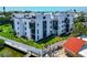 White condo building with private balconies overlooking lush landscaping and nearby docks at 2955 N Beach Rd # A422, Englewood, FL 34223